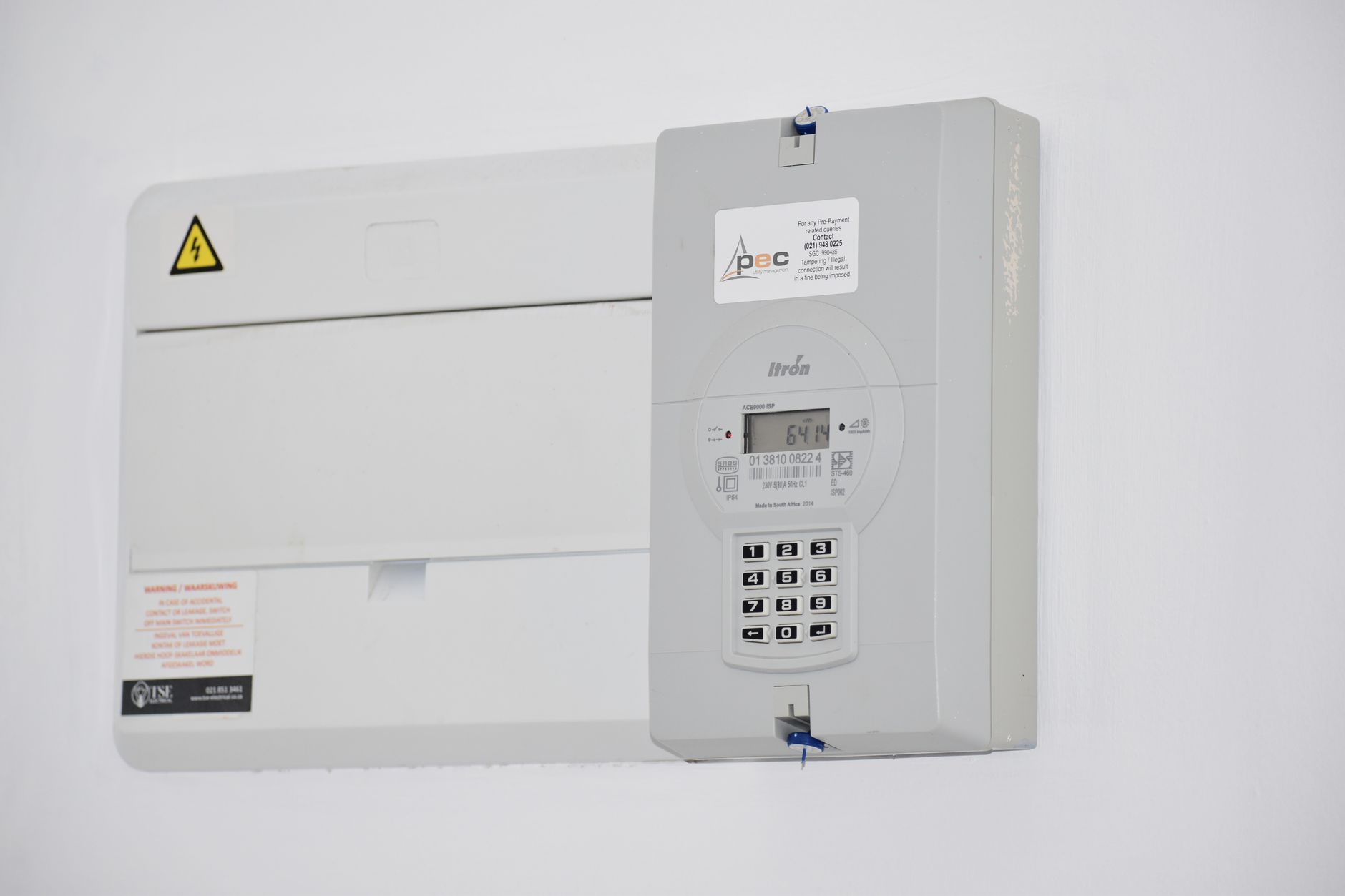 electrician using a clamp meter on a residential breaker panel